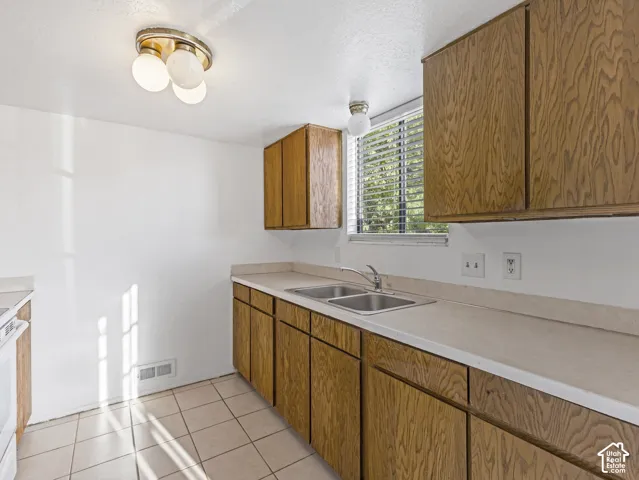 Unit A-Kitchen featuring solid wood cabinets and fridge.