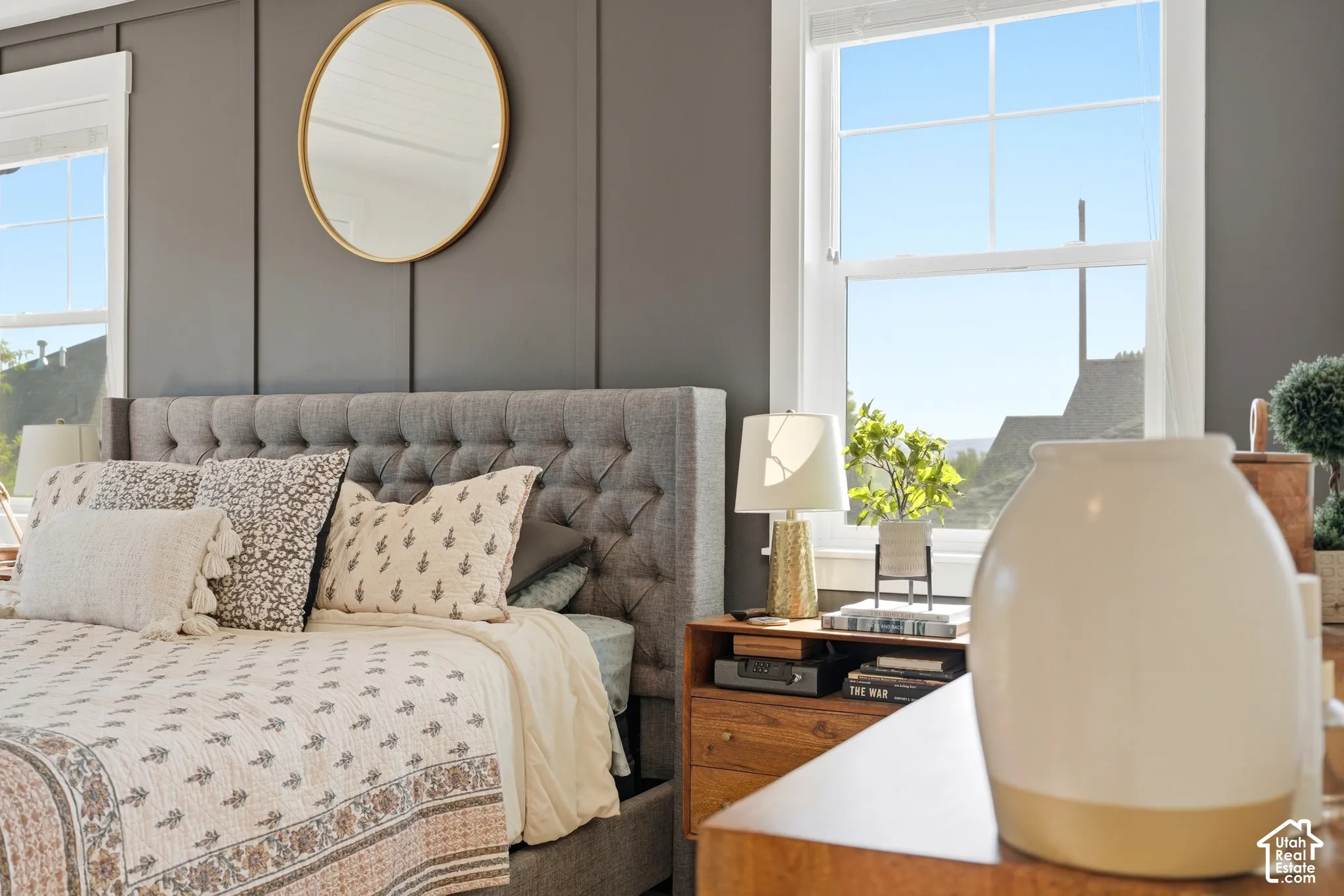 Bedroom featuring board-and-batten wall detailing, large double-hung windows with muntins, and neutral-toned wall finish