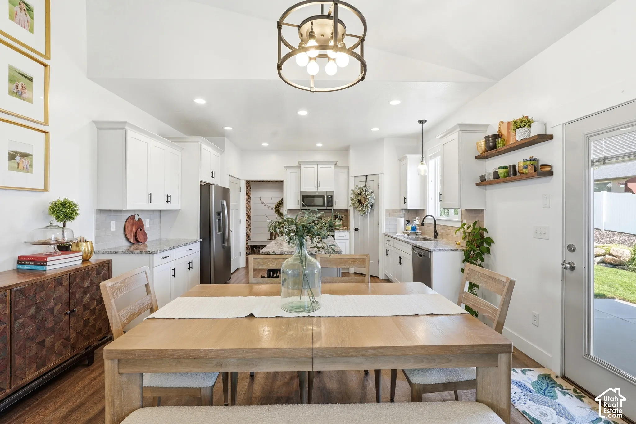 Kitchen featuring white shaker-style cabinetry, stone countertops, stainless steel appliances, recessed lighting, and a drum-style pendant light