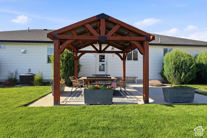 Covered timber-frame pergola featuring a metal roof, concrete patio, and mature landscaping