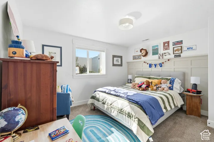 Neutral carpet flooring, horizontal grid wall paneling, and a flush-mount drum ceiling light fixture