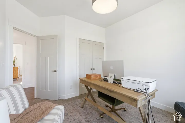 Neutral-toned interior space featuring light-colored wall-to-wall carpeting, grey-painted shaker-style interior doors, and a neutral drum-style ceiling light fixture