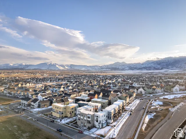 Aerial perspective of a multi-level residential development featuring contemporary architectural design, expansive mountain backdrops, and paved roadway access