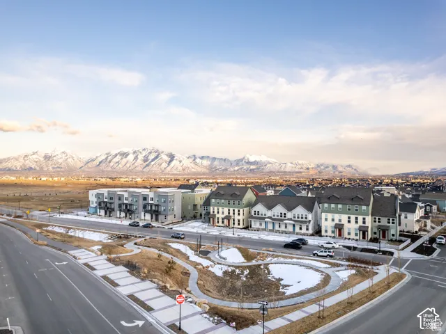 Multi-family residential community featuring multi-story exteriors with varied facades and gable rooflines, situated with a prominent snow-capped mountain backdrop