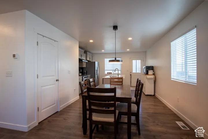 Wood-finish flooring, recessed lighting, central pendant light, solid-core interior door, and window blinds