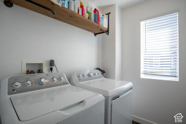 Utility area featuring a wall-mounted wood-finish shelf with industrial-style metal piping brackets and a window with horizontal blinds