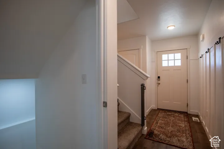 Entryway featuring wainscoting detail, wood-finish flooring, a multi-pane glass insert door, and a flush-mount ceiling light fixture