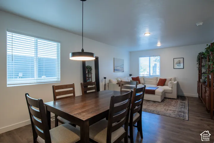Wood-finish flooring, neutral walls, recessed lighting, and contemporary pendant fixture