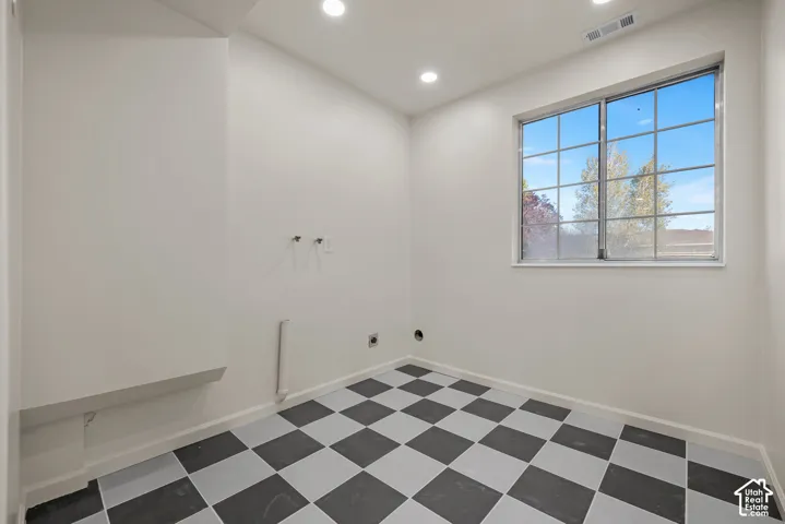 Utility room featuring a checkered tile floor, recessed lighting, and a large grid-pattern window