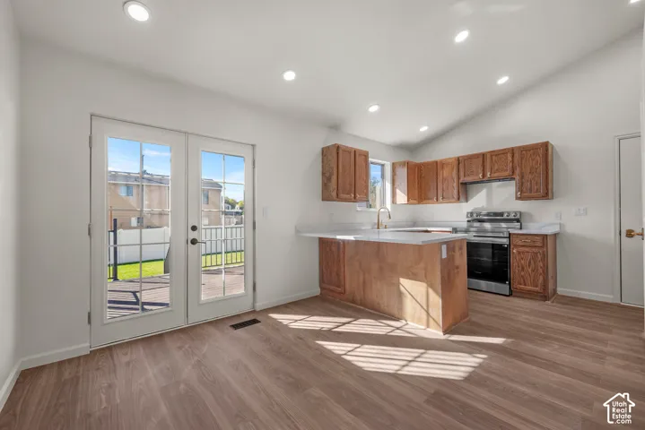 Kitchen featuring wood-finish cabinetry, white countertops, recessed lighting, wood-finish flooring, and double French doors