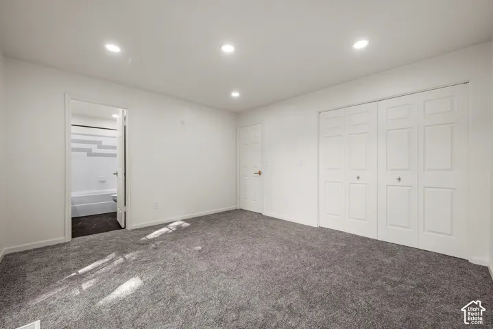 Room featuring neutral carpeting, recessed ceiling lighting, a closet with double-panel doors, and an interior door with a metallic handle