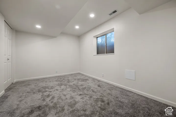 Neutral-toned carpeted flooring, recessed lighting, and a single-panel closet door