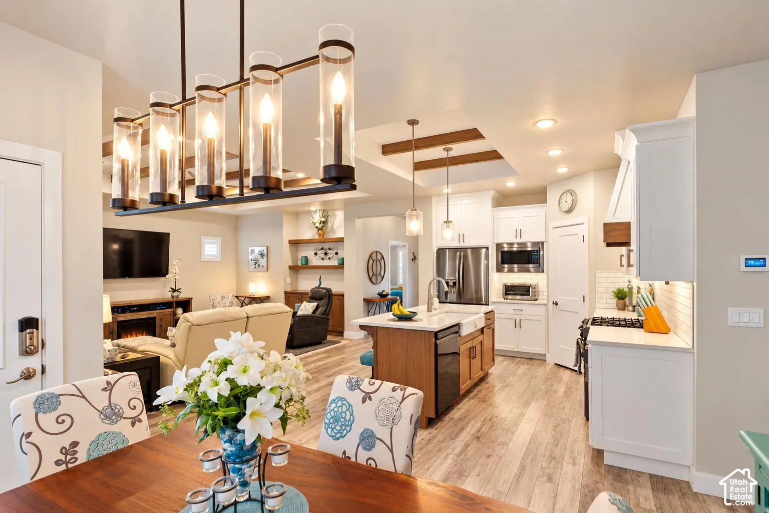 Kitchen featuring a center island with farmhouse sink, shaker-style cabinetry, stainless steel appliances, and a coffered ceiling with wood beams