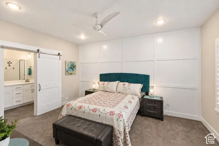 Room featuring extensive board and batten wall detailing, white sliding barn door, recessed ceiling lighting, and a modern three-blade ceiling fan
