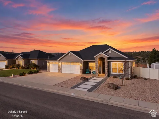 The Godfrey. Single-story residence featuring a stone-accented entryway, dual-bay 3-car garage, horizontal siding, and a paved walkway