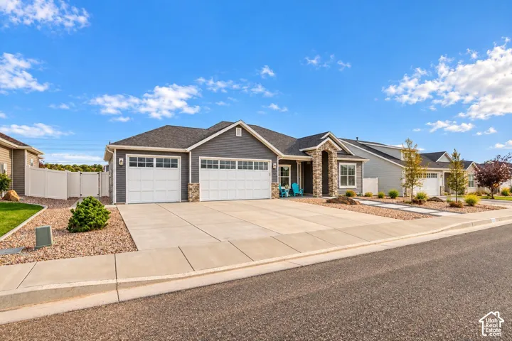 Single-story residence featuring horizontal lap siding, stone veneer accents, a three-car garage, and a concrete driveway