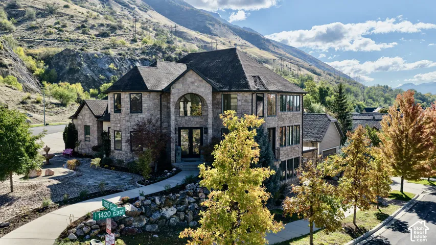 Multi-story stone exterior featuring a complex roofline, arched entryway, large windows for amazing views.l