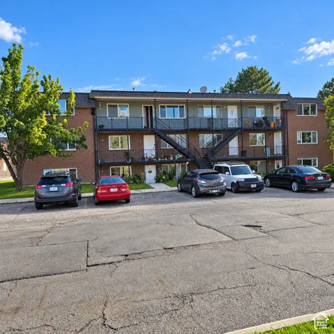 Top floor unit with brick exterior featuring metal staircases and private balcony railings