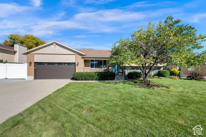 Single-story residence featuring a brick and vinyl siding exterior, attached two-car garage, concrete driveway, and front lawn landscaping