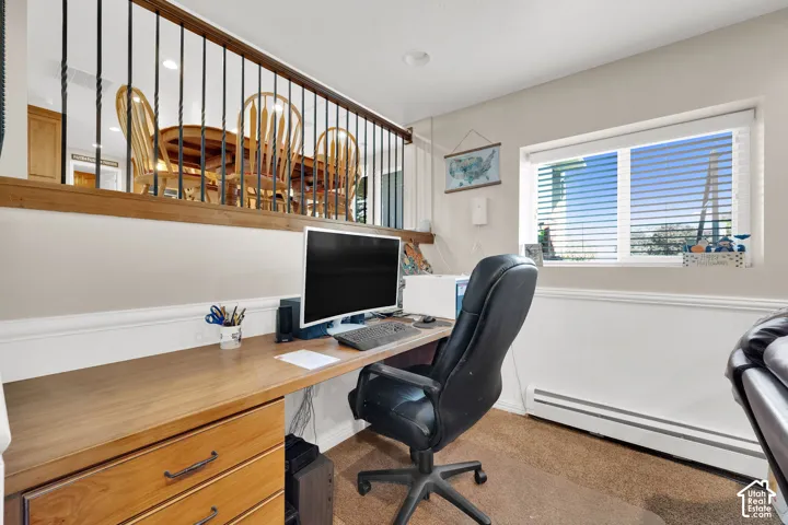 Built-in wooden desk featuring integrated storage drawers and a wide work surface, complemented by half-wall wainscoting and a metal spindle railing