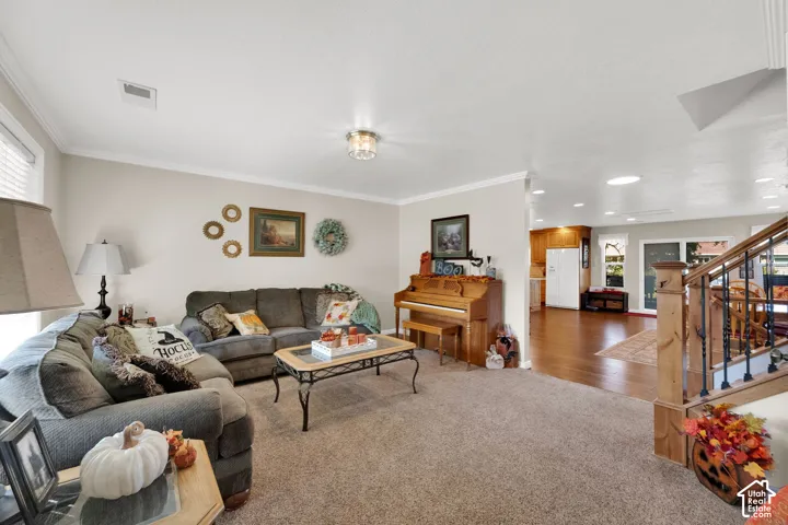 Living area featuring wall-to-wall carpeting, crown molding, and recessed lighting