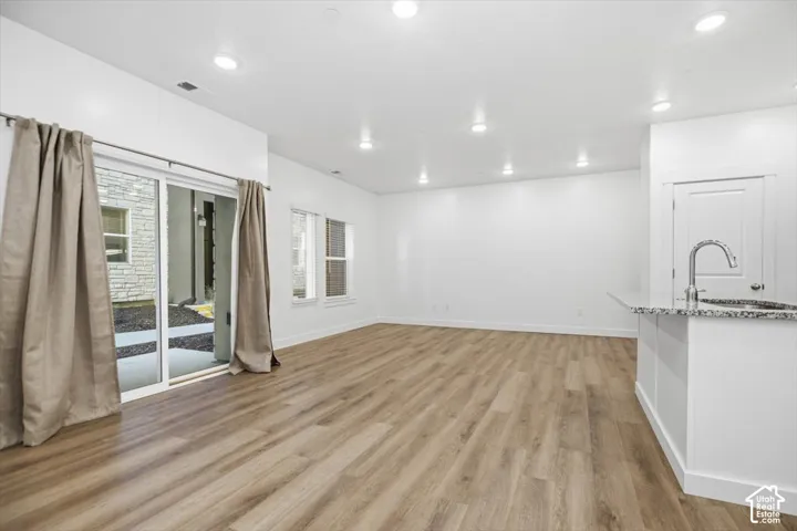 Open floor plan featuring wood-finish flooring, recessed lighting, and sliding glass doors