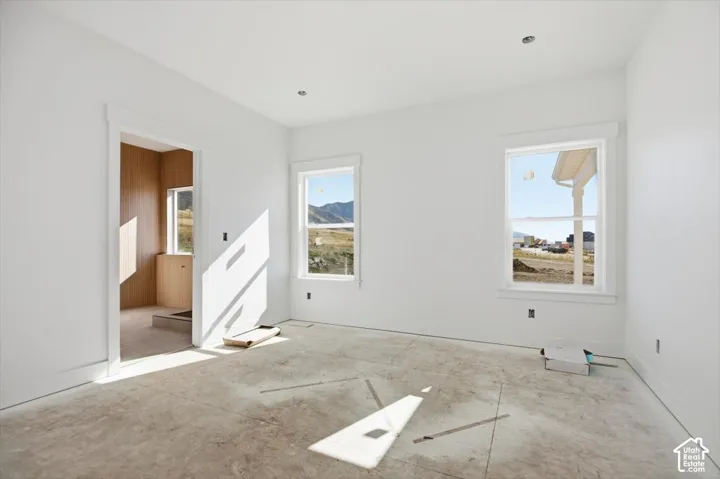 Room featuring white walls, recessed ceiling lighting, and double-pane windows with mountain scenery