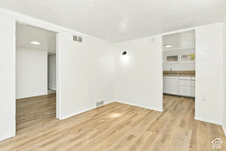 Neutral interior featuring wood-finish flooring, white walls, and recessed ceiling lighting