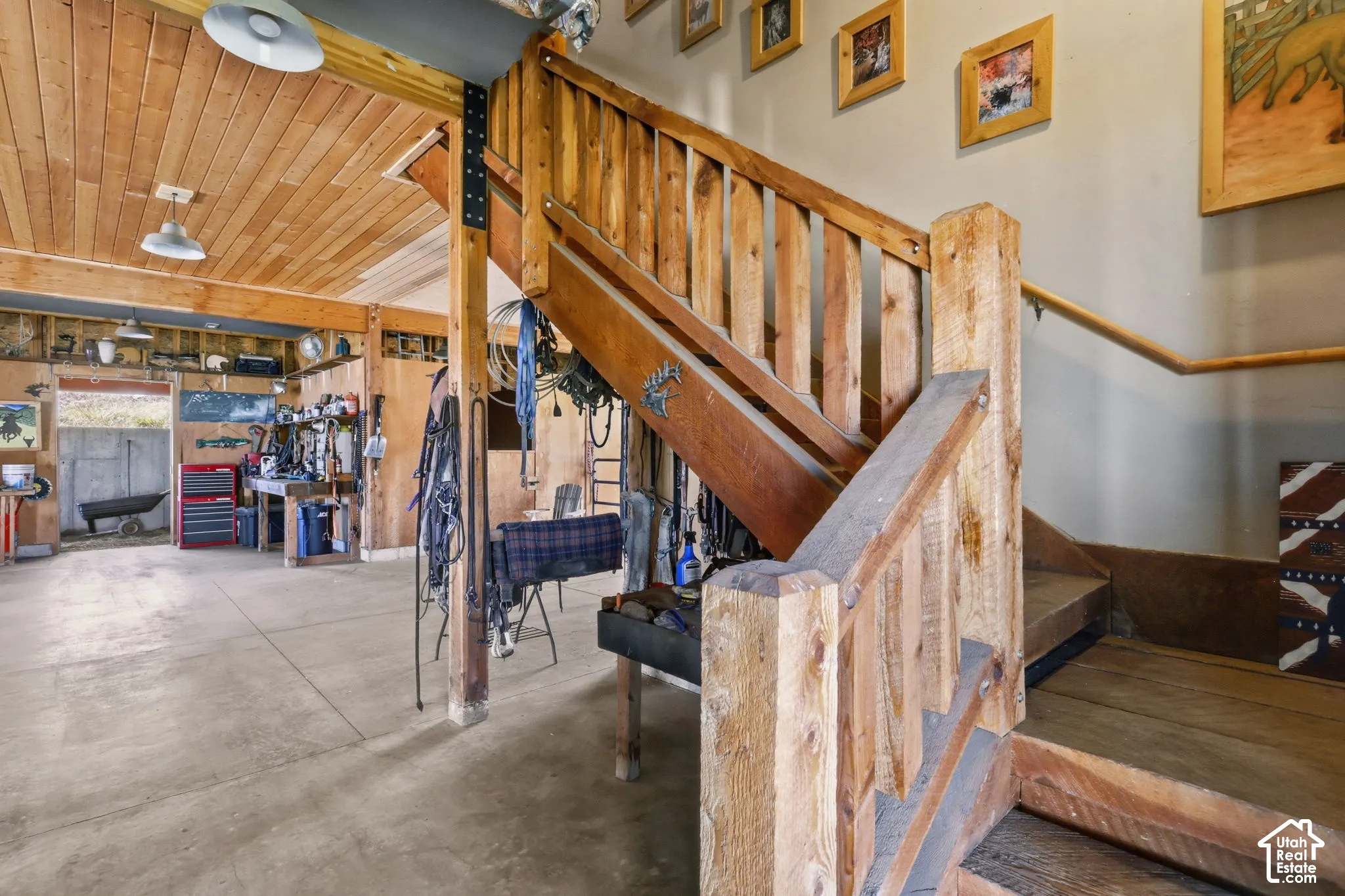 Custom staircase featuring heavy timber posts and balusters, tongue-and-groove wood ceiling, exposed structural beam, and expansive concrete flooring