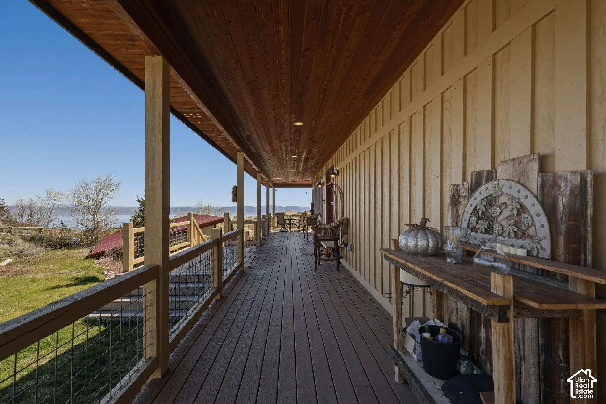 Covered exterior deck featuring wood-finish decking, tongue-and-groove wood ceiling, integrated recessed lighting, and wire mesh railings