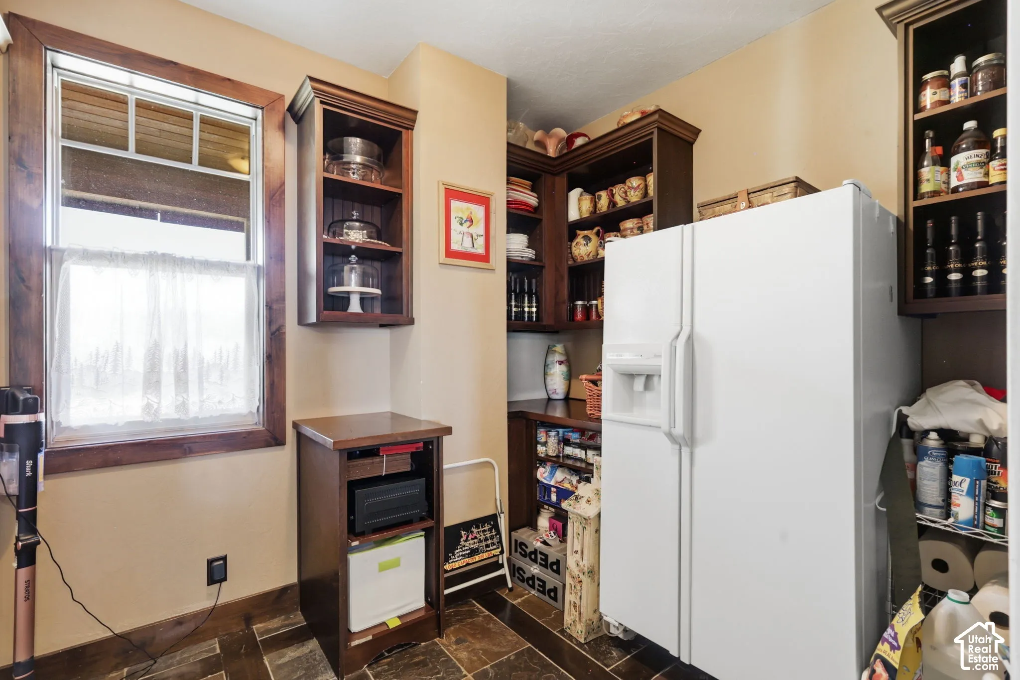 Custom built-in dark wood cabinetry, multi-level open shelving, and tile flooring