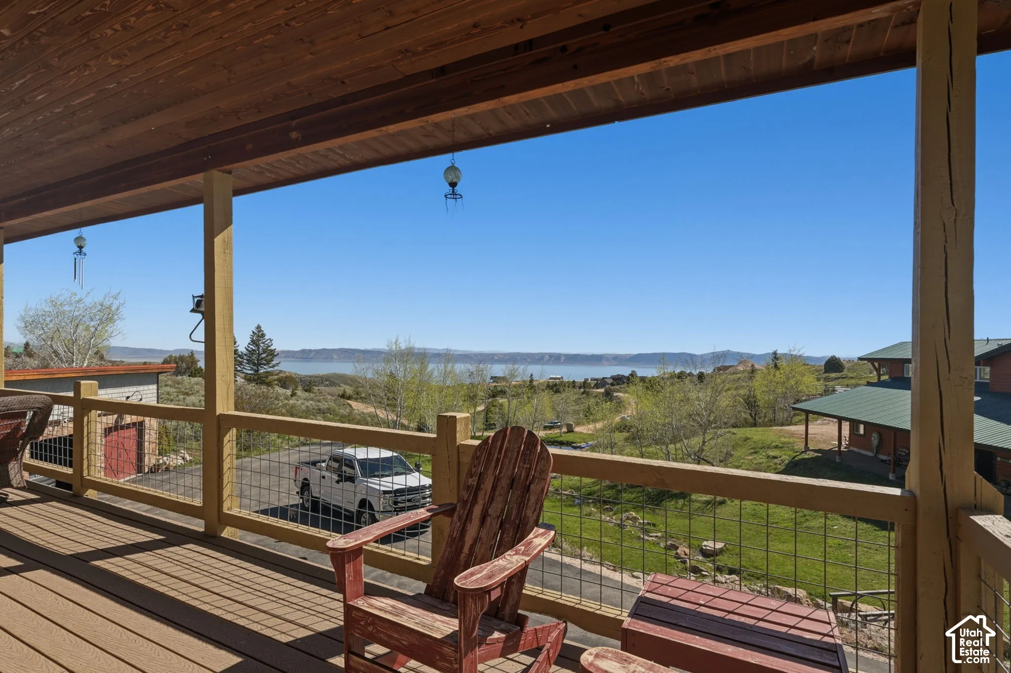 Covered exterior deck featuring wood-plank ceiling, structural timber support posts, and metal wire railing