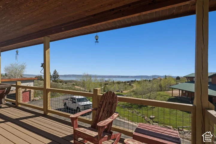 Covered exterior deck featuring wood-plank ceiling, structural timber support posts, and metal wire railing