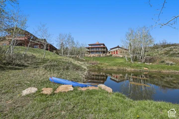 Expansive acreage featuring a private pond, rolling natural landscape, mature birch trees, and multi-level structures with detached garage