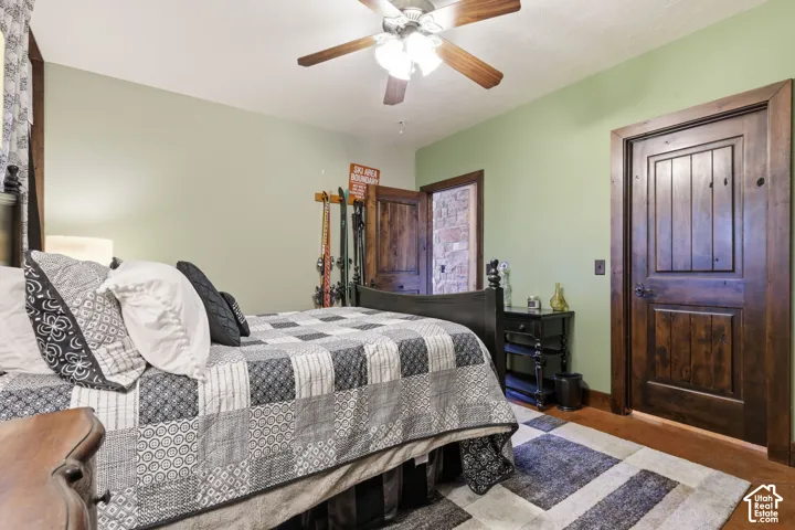 Stained wood doors with matching door casing, wood-finish flooring, and a ceiling fan with integrated lighting