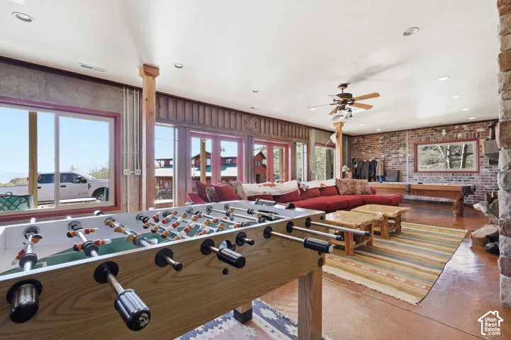 Interior space featuring exposed brick walls, stone masonry accents, stained concrete flooring, recessed lighting, and expansive glass sliding doors