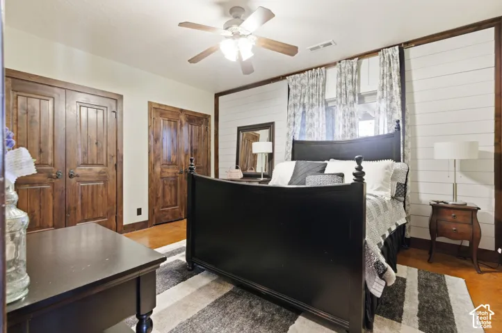 Horizontal plank wall detailing, stained wood-finish interior doors, and a ceiling-mounted light fixture with a multi-blade fan