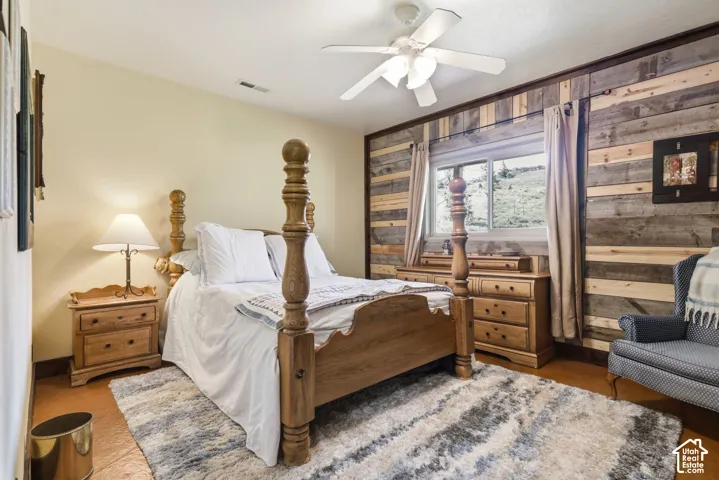 Horizontal wood-plank accent wall, multi-tone wood paneling, ceiling fan with integrated lighting, and dual-pane window