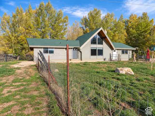 A-frame style residence featuring horizontal siding, multi-pane floor-to-ceiling windows, and a green shingle roof