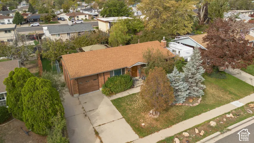 Single-story brick exterior featuring an attached one-car garage, concrete driveway, and mature landscaping