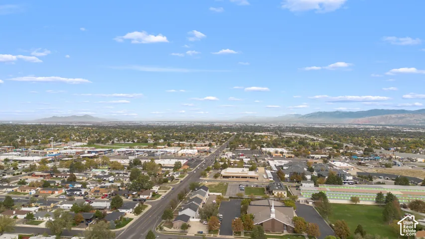 Aerial perspective featuring expansive horizon, mountain range backdrop, and established suburban surroundings