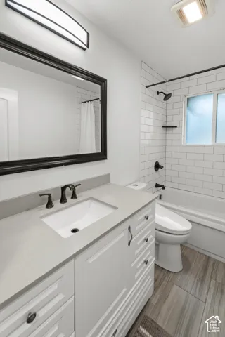 White cabinetry featuring a quartz countertop and integrated sink, complemented by black hardware and fixtures