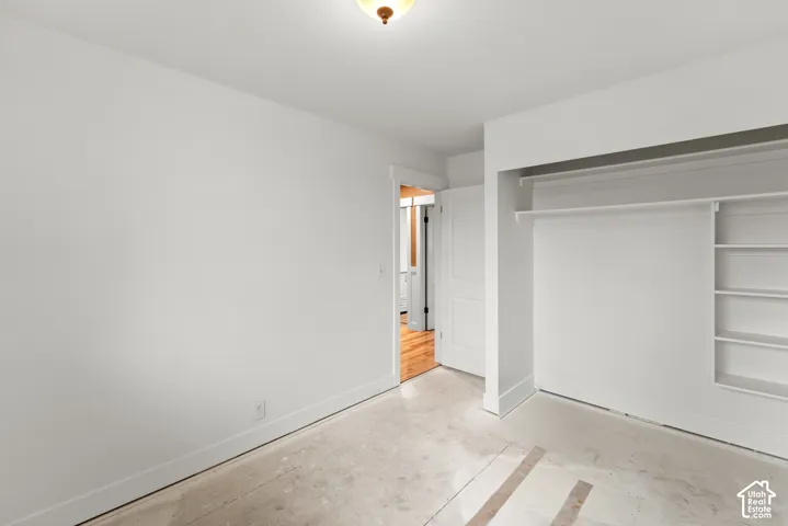 Interior space featuring crisp white walls, flush-mount ceiling lighting, a solid-core door, and a built-in closet system with integrated shelving