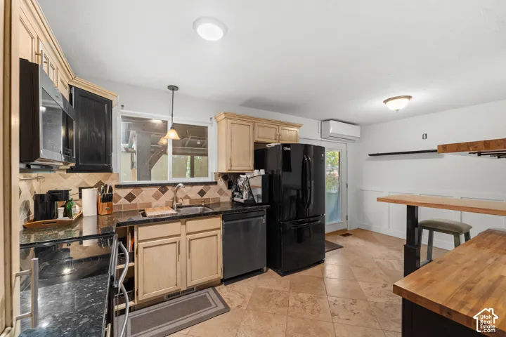 Kitchen featuring two-tone wood cabinetry, dark stone countertops, diagonal tile backsplash, tile flooring, and a built-in wood-topped peninsula