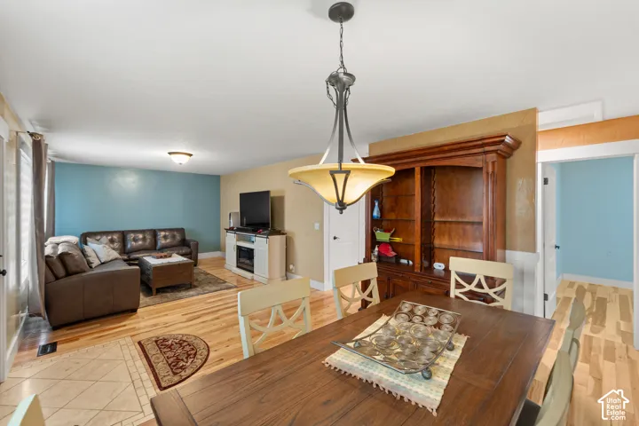 Hardwood flooring, multi-tier metal pendant lighting, and built-in stained wood cabinetry