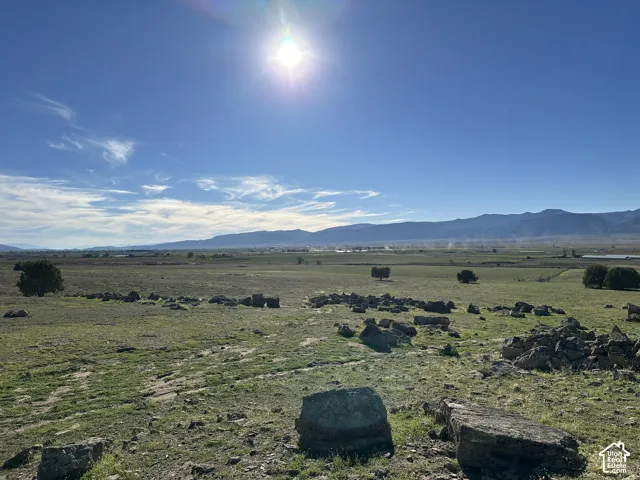 Expansive lot featuring natural rock outcroppings, native grasses, and unobstructed mountain backdrops