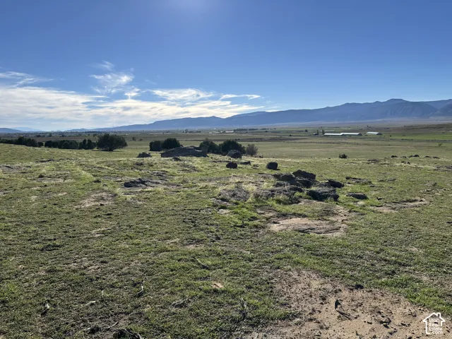 Expansive acreage featuring native grasses, natural rock outcroppings, and mountain silhouettes