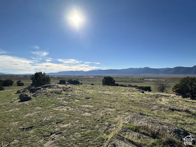 Expansive undeveloped acreage featuring natural rock outcroppings, native vegetation, and a prominent mountain range backdrop