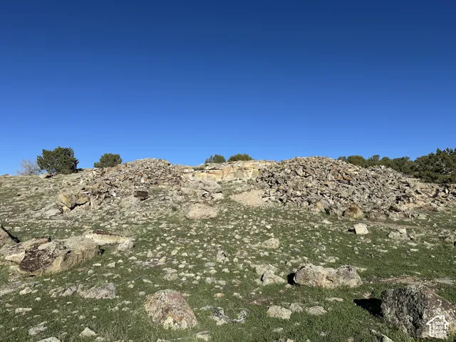 Expansive lot featuring natural rock outcroppings, native grasses, and mature juniper trees
