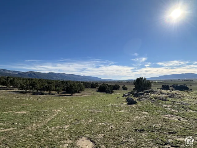 Expansive acreage featuring rugged mountain backdrops, natural rock outcroppings, scattered mature trees, and native vegetation
